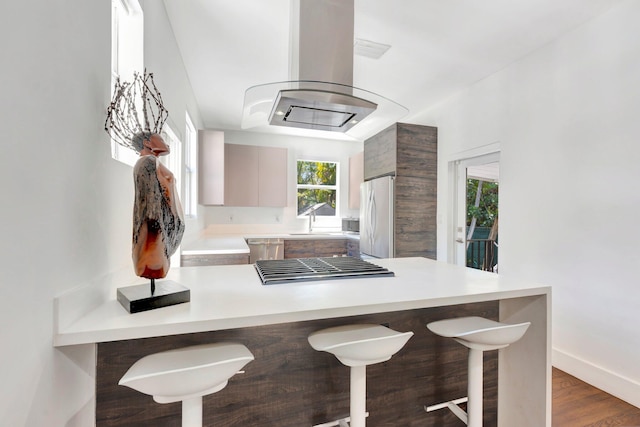 430 NE 121st St, Biscayne Park, FL 33161 - kitchen with freestanding refrigerator, light countertops, a peninsula, and a kitchen bar