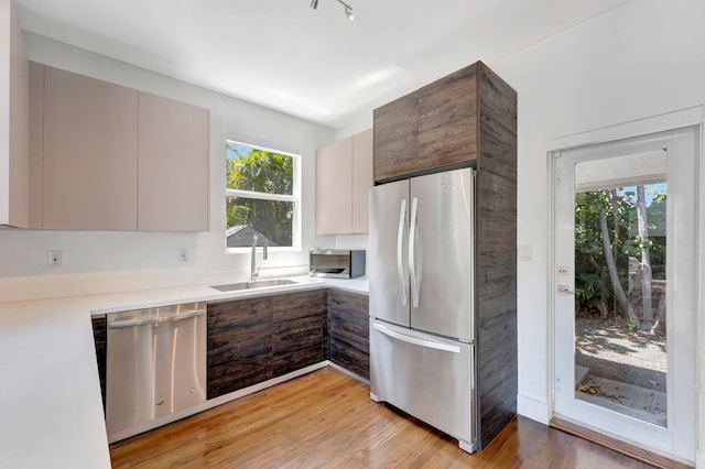 430 NE 121st St, Biscayne Park, FL 33161 - kitchen with modern cabinets, a sink, light wood-style floors, light countertops, and appliances with stainless steel finishes