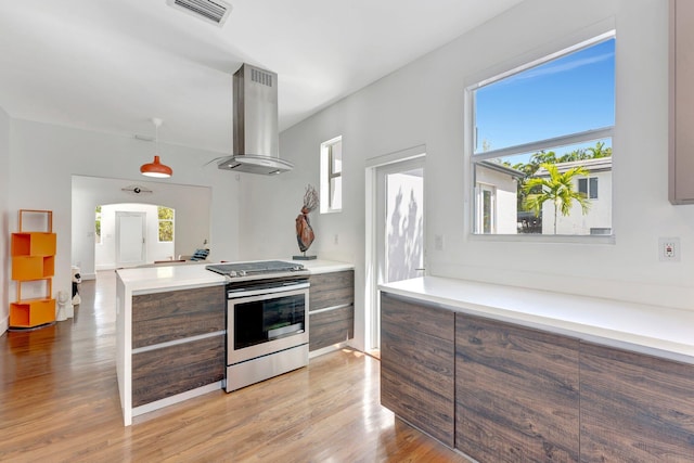 430 NE 121st St, Biscayne Park, FL 33161 - kitchen with light wood finished floors, modern cabinets, visible vents, stainless steel range with gas cooktop, and wall chimney range hood