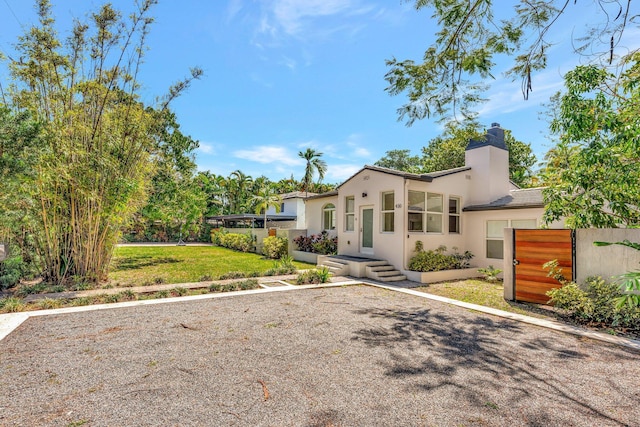 430 NE 121st St, Biscayne Park, FL 33161 - mediterranean / spanish home with stucco siding, a front lawn, and a chimney