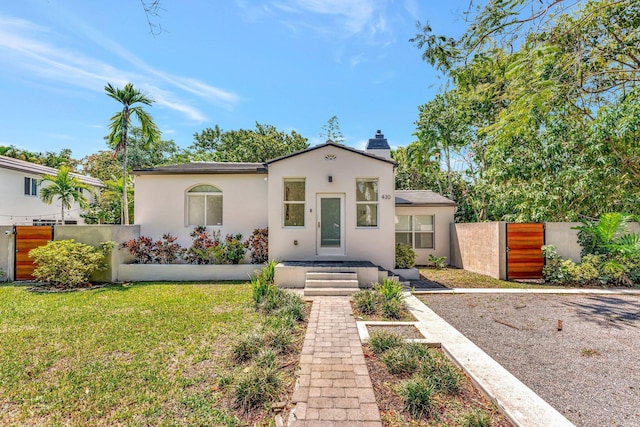 430 NE 121st St, Biscayne Park, FL 33161 - mediterranean / spanish-style house with stucco siding, a front lawn, fence, and a gate