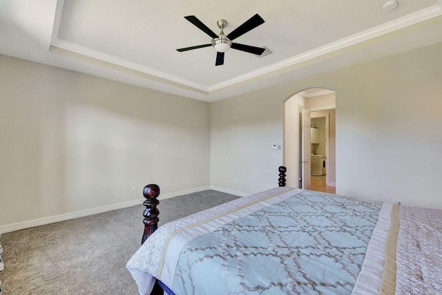 964 SW Canoe Creek Ter, Palm City, FL 34990 - carpeted bedroom featuring a tray ceiling, crown molding, washing machine and dryer, and arched walkways