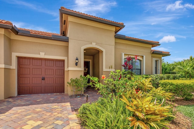 964 SW Canoe Creek Ter, Palm City, FL 34990 - view of front of home featuring an attached garage, stucco siding, a tiled roof, and driveway