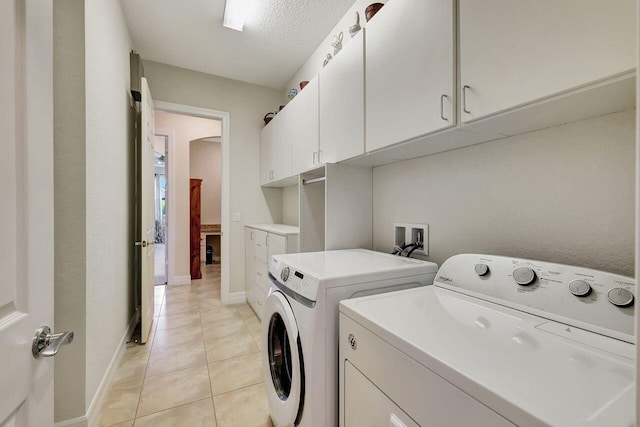 964 SW Canoe Creek Ter, Palm City, FL 34990 - laundry area featuring light tile patterned floors, baseboards, washing machine and dryer, and cabinet space