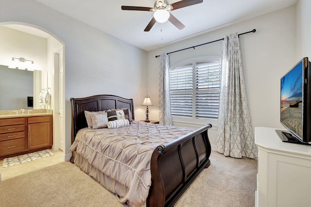 964 SW Canoe Creek Ter, Palm City, FL 34990 - bedroom with light colored carpet, ensuite bathroom, ceiling fan, and arched walkways