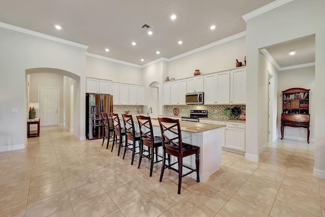 964 SW Canoe Creek Ter, Palm City, FL 34990 - kitchen featuring arched walkways, visible vents, tasteful backsplash, and appliances with stainless steel finishes