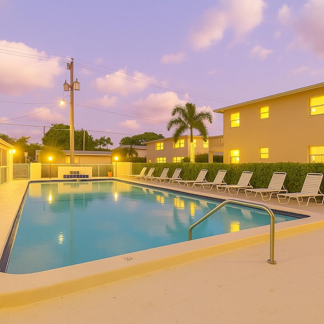 community pool with fence and a patio