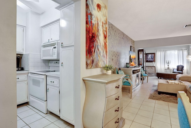 kitchen with white appliances, open floor plan, light tile patterned flooring, light countertops, and white cabinetry