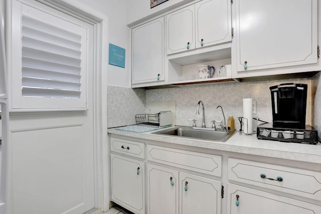 kitchen featuring a sink, light countertops, and white cabinets