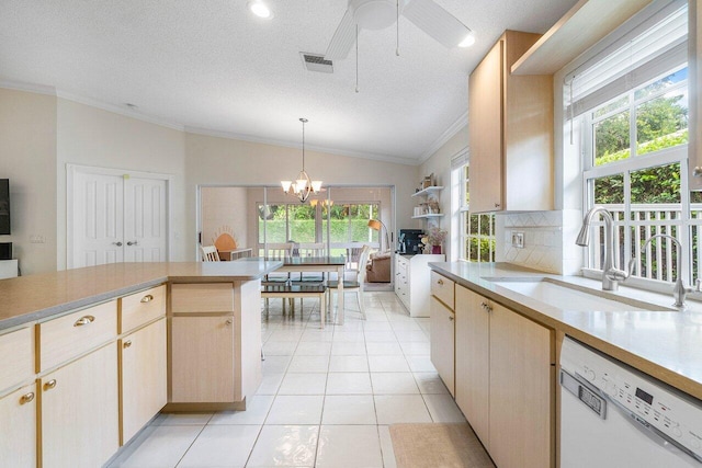 kitchen featuring dishwasher, light countertops, crown molding, and a sink