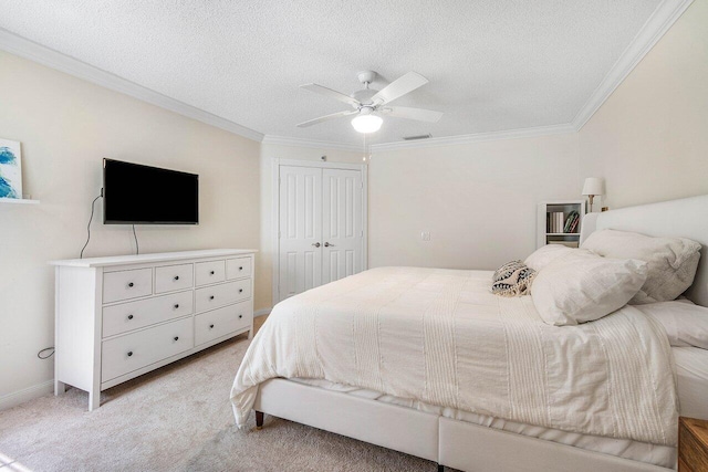 bedroom featuring a ceiling fan, a closet, crown molding, and light colored carpet