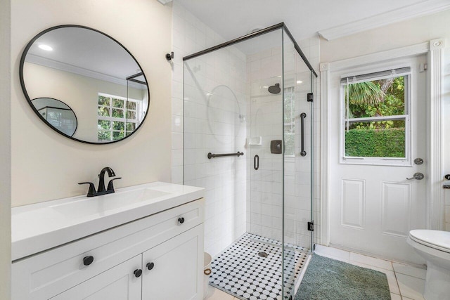 full bathroom featuring a stall shower, ornamental molding, toilet, and plenty of natural light