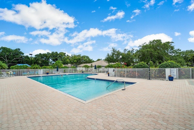 pool with a patio and fence