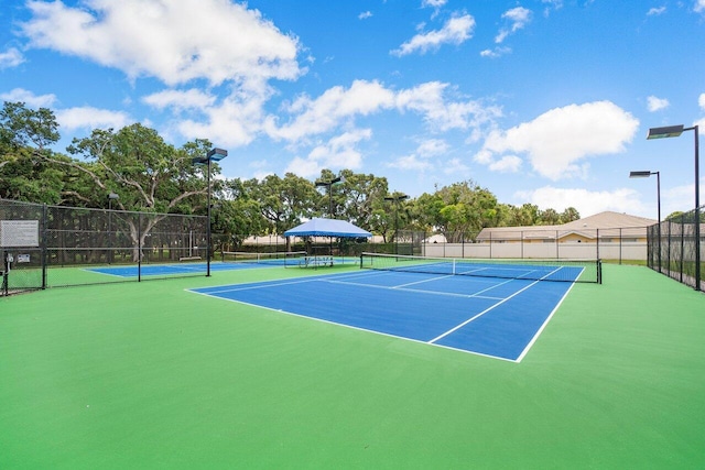 view of tennis court featuring fence
