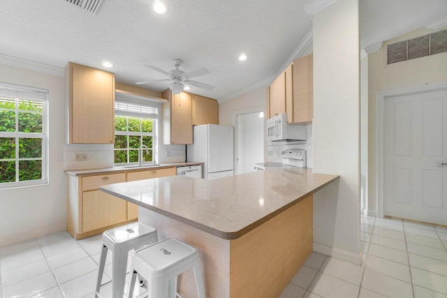 kitchen with white appliances, a peninsula, crown molding, and tasteful backsplash