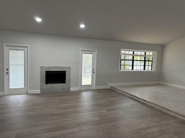 unfurnished living room with a high end fireplace, baseboards, wood finished floors, and recessed lighting