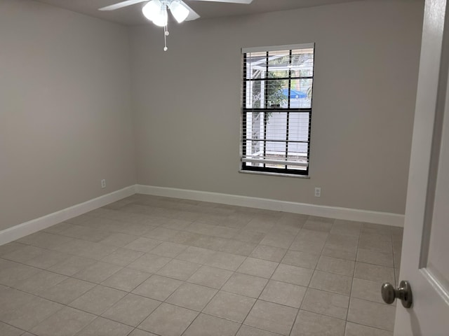 spare room featuring a ceiling fan and baseboards