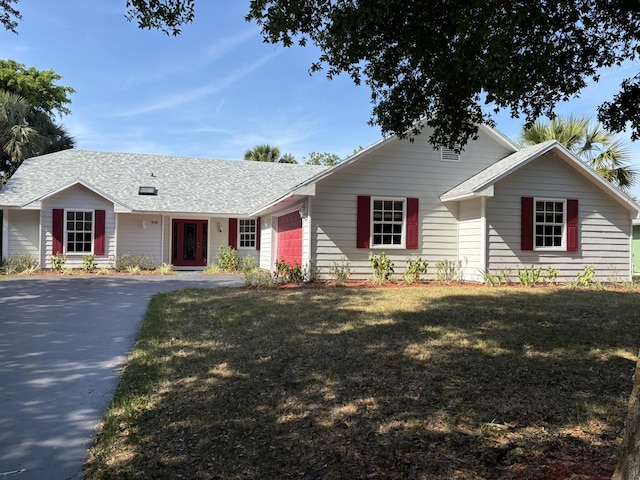 single story home with a garage, a front lawn, roof with shingles, and driveway