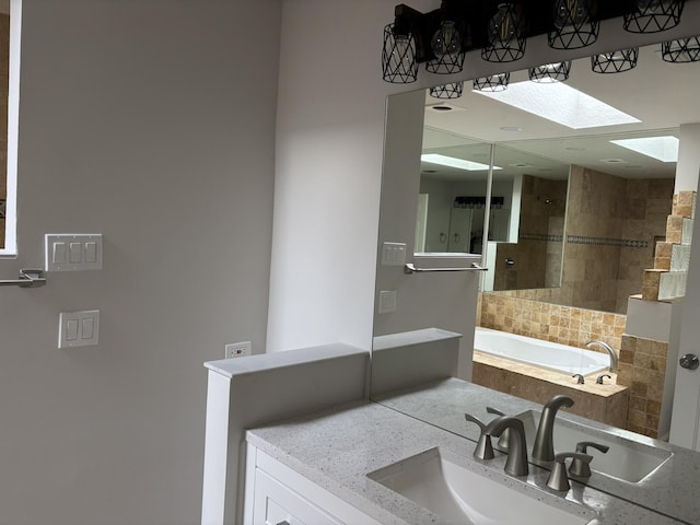 full bathroom featuring a tile shower, a skylight, a tub to relax in, and vanity