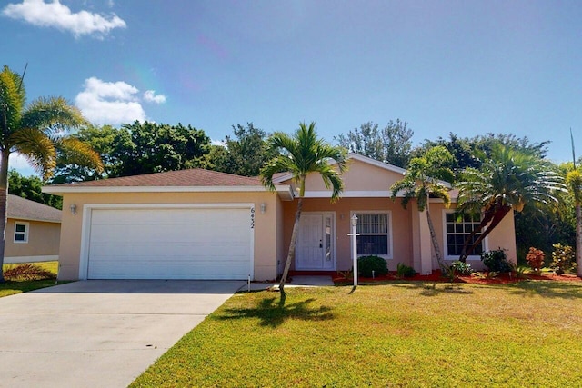 ranch-style house featuring an attached garage, stucco siding, driveway, and a front lawn