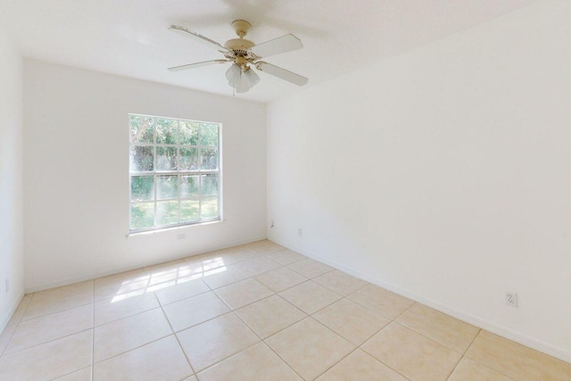 unfurnished room with light tile patterned flooring, baseboards, and a ceiling fan