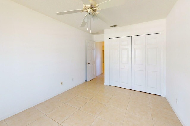 unfurnished bedroom with ceiling fan, a closet, visible vents, and light tile patterned flooring