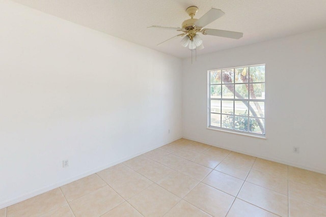 spare room with light tile patterned floors, baseboards, and a ceiling fan