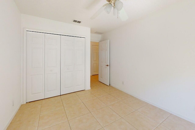 unfurnished bedroom featuring light tile patterned floors, baseboards, a closet, and visible vents