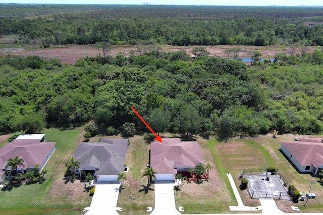 drone / aerial view featuring a wooded view