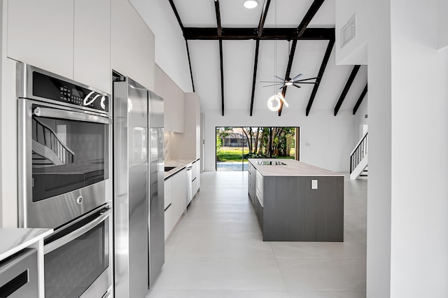 6560 Las Flores Dr, Boca Raton, FL 33433 - kitchen featuring modern cabinets, stainless steel appliances, light countertops, white cabinetry, and a kitchen island