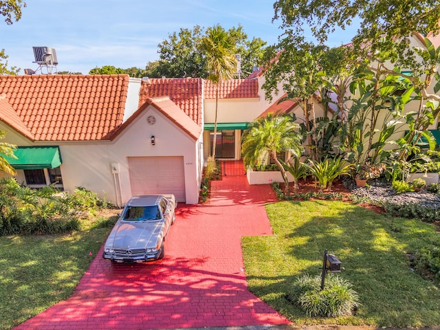 6560 Las Flores Dr, Boca Raton, FL 33433 - mediterranean / spanish house with an attached garage, a tiled roof, stucco siding, a front yard, and driveway
