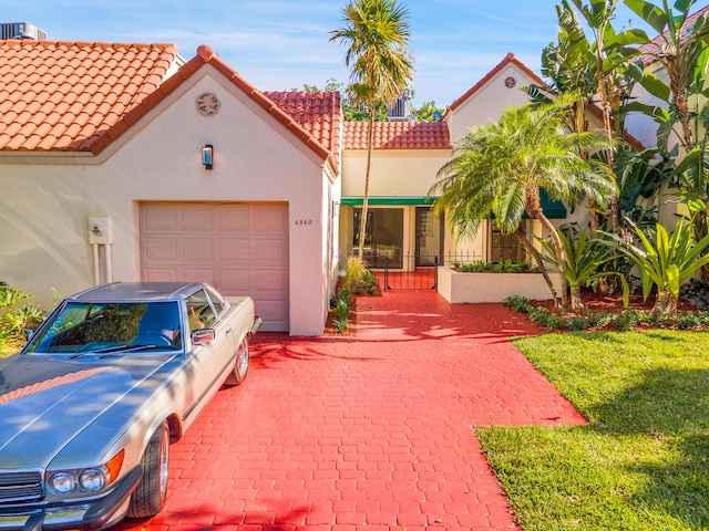 6560 Las Flores Dr, Boca Raton, FL 33433 - mediterranean / spanish-style home with a tiled roof, stucco siding, and an attached garage
