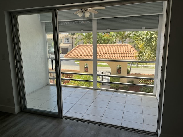 doorway to outside with a ceiling fan, a textured wall, and wood finished floors