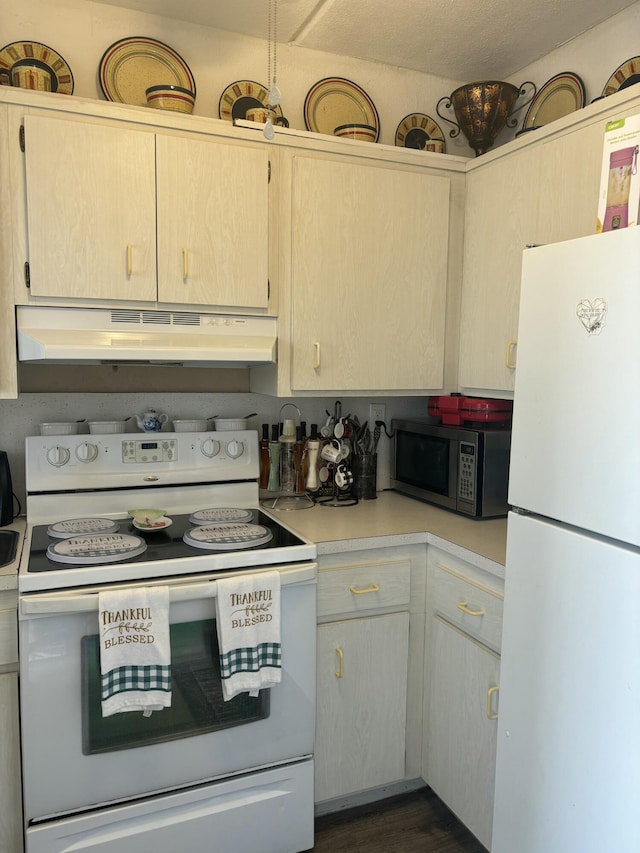 kitchen featuring under cabinet range hood, light countertops, dark wood-style flooring, and white appliances