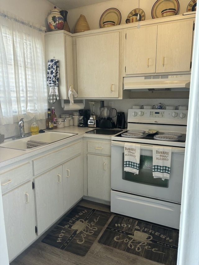 kitchen with under cabinet range hood, light countertops, white range with electric cooktop, and a sink