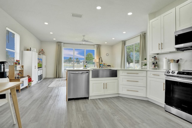 kitchen featuring a sink, visible vents, a ceiling fan, white cabinets, and appliances with stainless steel finishes