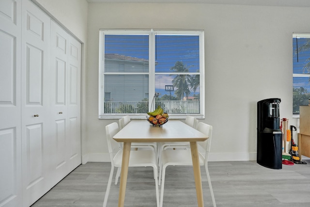dining room with baseboards and light wood-type flooring