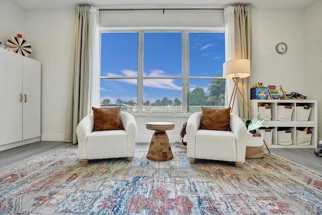 living area with baseboards and wood finished floors