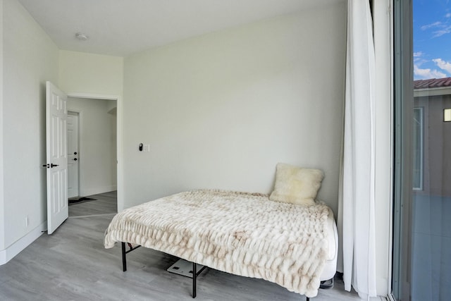 bedroom with wood finished floors and baseboards