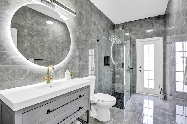 full bathroom with tile walls, a shower stall, toilet, and a healthy amount of sunlight