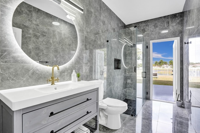 full bathroom featuring a stall shower, vanity, tile walls, and toilet