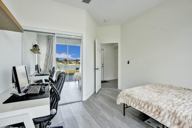 bedroom with light wood finished floors, access to outside, baseboards, and visible vents