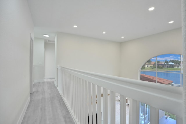 hallway featuring recessed lighting, plenty of natural light, and wood finished floors