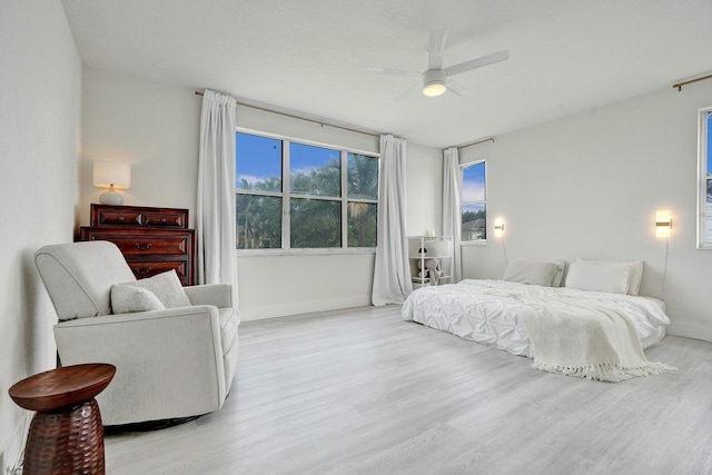 bedroom featuring ceiling fan, baseboards, and wood finished floors
