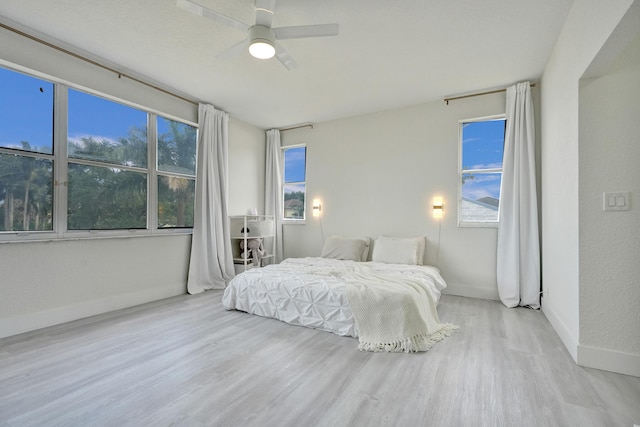 bedroom with baseboards, ceiling fan, and wood finished floors