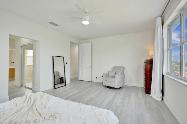 bedroom featuring baseboards, multiple windows, light wood finished floors, and visible vents