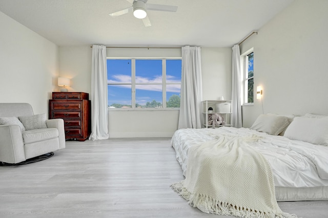 bedroom featuring baseboards, a ceiling fan, and wood finished floors