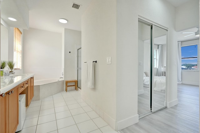 bathroom with connected bathroom, an enclosed shower, a garden tub, visible vents, and vanity