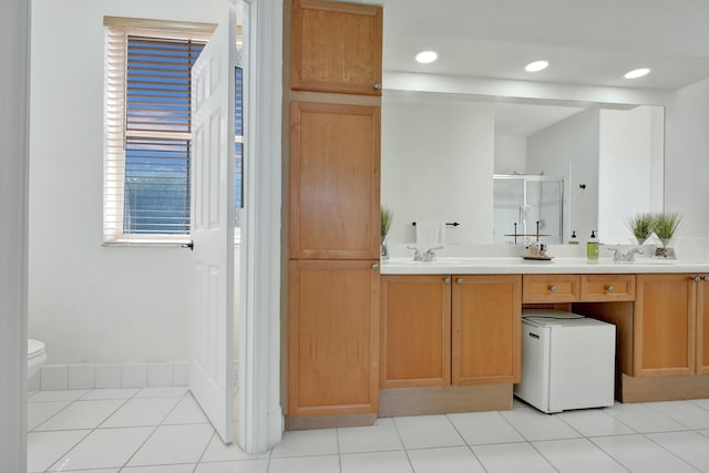bathroom with a sink, toilet, recessed lighting, a stall shower, and double vanity