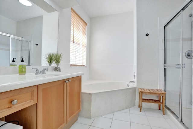 bathroom with tile patterned floors, vanity, a stall shower, and a garden tub
